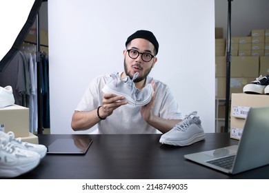Young attractive Asian man blogger or vlogger looking at camera reviewing product. Modern businessman using social media for marketing. Business online influencer on social media concept.