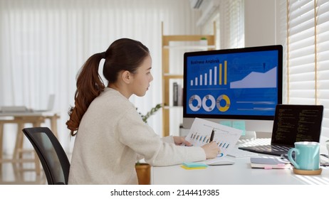 Young Attractive Asian Thai Woman Employee Busy Work Online Multiple Screen Laptop Computer Or Smart Tablet At Home In Freelance Sale Data Analytic, Data Science Scientist Engineer For Business.