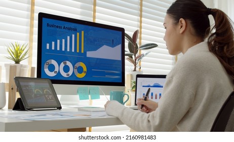 Young Attractive Asian Thai Woman Employee Busy Work Online Multiple Screen Laptop Computer Or Smart Tablet At Home In Freelance Sale Data Analytic, Data Science Scientist Engineer For Business.