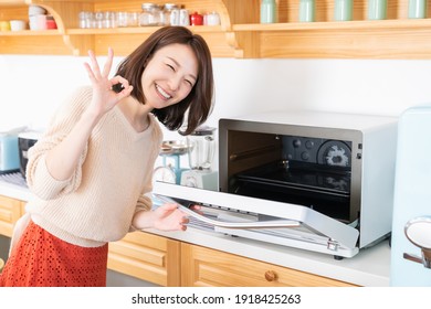 Young Attractive Asian Woman Cooks In A Kitchen,oven,