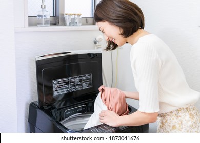 Young Attractive Asian Woman Doing The Laundry