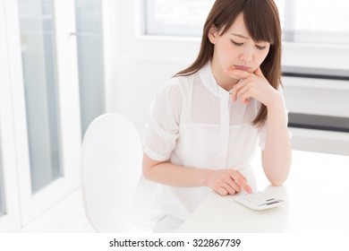 Young Attractive Asian Woman Having An Electronic Calculator