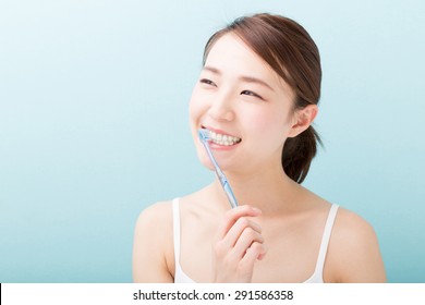 Young Attractive Asian Woman With Healthy Teeth Holding A Tooth Brush