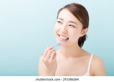 Young Attractive Asian Woman With Healthy Teeth Holding A Tooth Brush