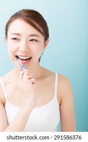 Young Attractive Asian Woman With Healthy Teeth Holding A Tooth Brush