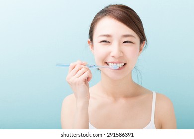 Young Attractive Asian Woman With Healthy Teeth Holding A Tooth Brush