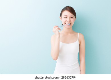 Young Attractive Asian Woman With Healthy Teeth Holding A Tooth Brush