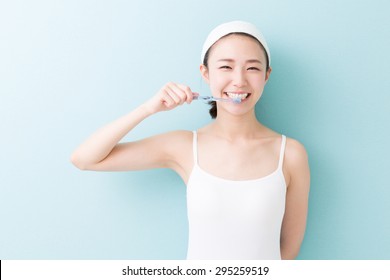 Young Attractive Asian Woman With Healthy Teeth Holding A Tooth Brush