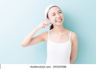 Young Attractive Asian Woman With Healthy Teeth Holding A Tooth Brush