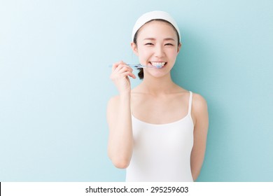 Young Attractive Asian Woman With Healthy Teeth Holding A Tooth Brush