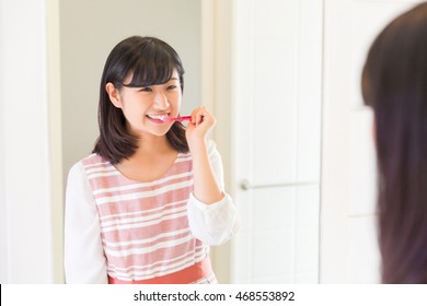 Young Attractive Asian Woman With Healthy Teeth Holding A Tooth Brush