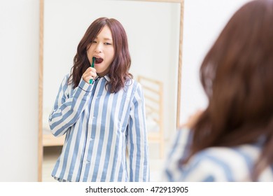 Young Attractive Asian Woman With Healthy Teeth Holding A Tooth Brush