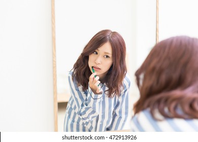 Young Attractive Asian Woman With Healthy Teeth Holding A Tooth Brush