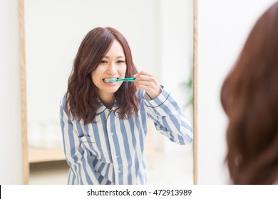 Young Attractive Asian Woman With Healthy Teeth Holding A Tooth Brush