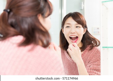 Young Attractive Asian Woman With Healthy Teeth Holding A Tooth Brush