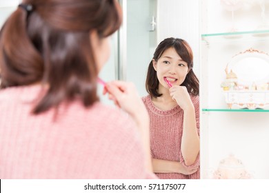 Young Attractive Asian Woman With Healthy Teeth Holding A Tooth Brush