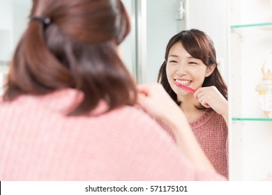 Young Attractive Asian Woman With Healthy Teeth Holding A Tooth Brush