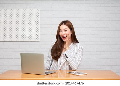 Young attractive Asian woman owner startup business using laptop computer and announce with hand, Small business SME concept