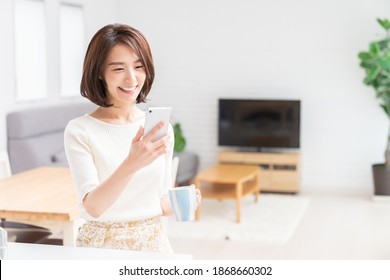 Young Attractive Asian Woman To See A Smart Phone