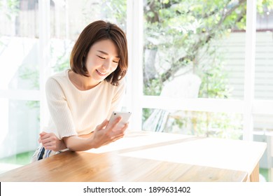 Young Attractive Asian Woman To See A Smart Phone,