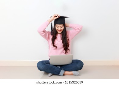 Young Attractive Asian Woman Sitting With Laptop On Her Legs Wearing Graduated Hat, Online Education Class, Scholarship Study Abroad Concept.