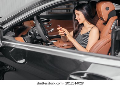 Young Attractive Asian Woman Using Phone While Sitting In A Luxury Car Front Sea