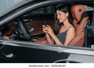 Young Attractive Asian Woman Using Phone While Sitting In A Luxury Car Front Sea