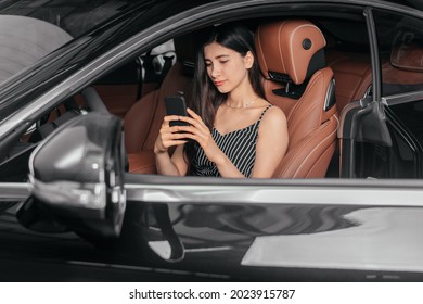 Young Attractive Asian Woman Using Phone While Sitting In A Luxury Car Front Sea