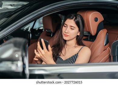 Young Attractive Asian Woman Using Phone While Sitting In A Luxury Car Front Sea