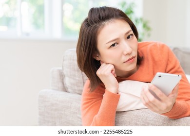 Young attractive Asian woman using a smartphone,think, - Shutterstock ID 2255485225