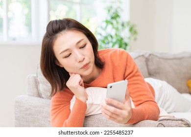 Young attractive Asian woman using a smartphone,think, - Shutterstock ID 2255485237