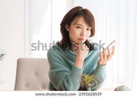 Young attractive Asian woman using a smartphone,think,