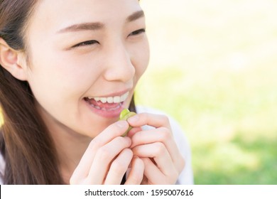 Young Attractive Asian Woman Who Eats Green Soybeans,outdoor,edamame