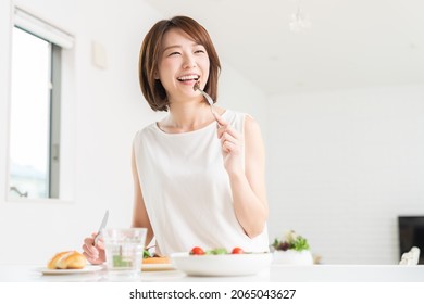 young attractive asian woman who eats - Shutterstock ID 2065043627