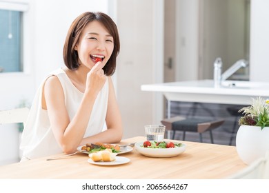 young attractive asian woman who eats - Powered by Shutterstock