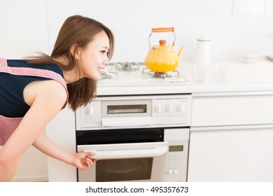 Young Attractive Asian Woman Who Cooks With An Oven