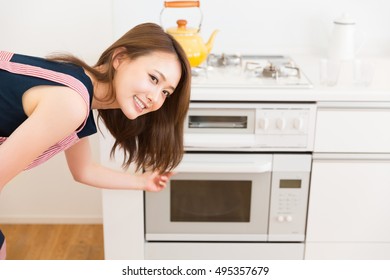 Young Attractive Asian Woman Who Cooks With An Oven