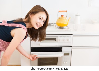 Young Attractive Asian Woman Who Cooks With An Oven