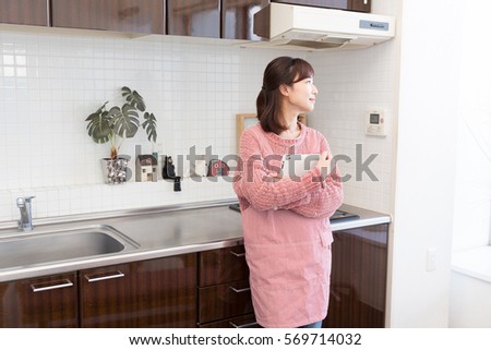 young attractive asian woman who cooks while watching tablet pc
