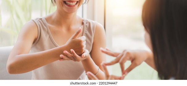 Young attractive Asian women using sign hand finger language conversation with deaf person. Cheerful happy using nonverbal communication to persons with disabilities. - Shutterstock ID 2201294447
