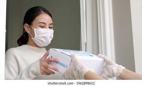 Young Attractive Beautiful Asian Female Receive Medication Package Box Free First Aid From Pharmacy Hospital Delivery Service At Home Wear Glove, Face Mask In Telehealth, Telemedicine Online Concept.