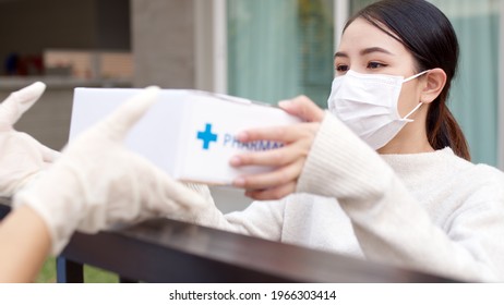 Young Attractive Beautiful Asian Female Receive Medication Package Box Free First Aid From Pharmacy Hospital Delivery Service At Home Wear Glove, Face Mask In Telehealth, Telemedicine Online Concept.