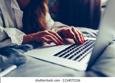 Young attractive and beautiful european woman 20s lying in bed at home using internet working on computer laptop smiling relaxed and cheerful at her bedroom in morning lifestyle concept. Toned photo