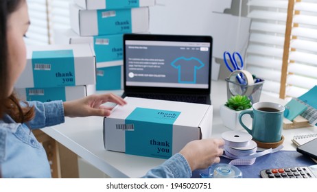 Young attractive beautiful hipster asia female packing product small business parcel order online retail store for delivery to customer. SME owner work preparing dropshipping box at home office.