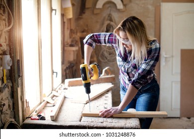 Young Attractive Blond Woman Is Working In Carpenter Workshop