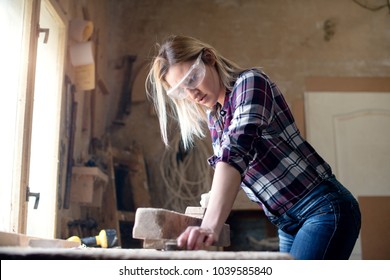 Young Attractive Blond Woman Is Working In Carpenter Workshop