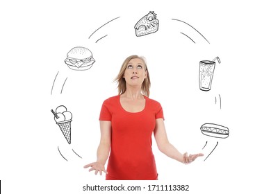 young and attractive blonde woman juggling multitudes of different fatty and sweet foods on white isolated studio background