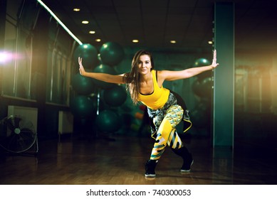 Young Attractive Brunette Woman Doing Zumba Dance Workout Alone In Gym. Toned Image.