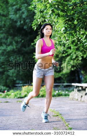 Eine junge Frau läuft im Freien in einem Park und widmet sich der Fitness und der Aufrechterhaltung eines gesunden Lebensstils