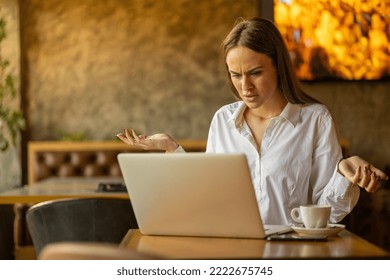 Young attractive business woman using laptop in caffe, looking worried - Shutterstock ID 2222675745